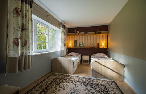 ein Wohnzimmer mit 2 Betten und einem Fenster in der Unterkunft Ninnujärve Private Holiday Home in Nasva