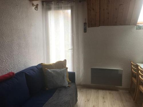 a living room with a blue couch and a window at Barèges Appartement vue montagne in Barèges