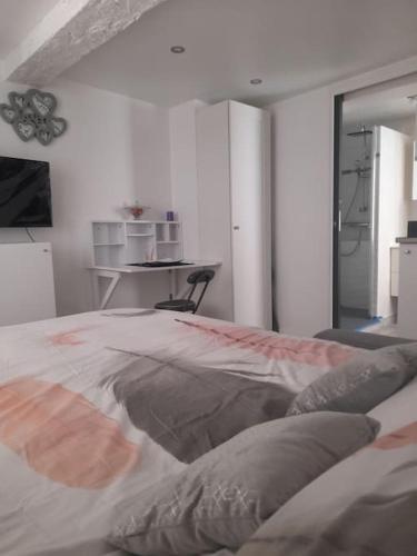 une chambre blanche avec un lit et une table dans l'établissement Studette centre historique refait à neuf 2022, à Fréjus