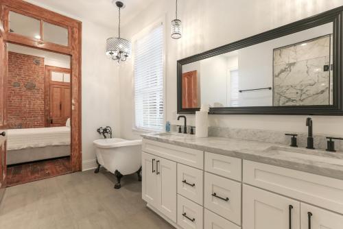 a bathroom with a tub and a sink and a bath tub at Canal Street Mini Mansion Sleeps 15 in New Orleans