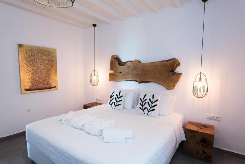 a bedroom with a white bed with towels on it at Bellou Suites in Mýkonos City