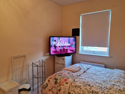 a bedroom with a bed and a flat screen tv at KELVIN HOUSE in Durham