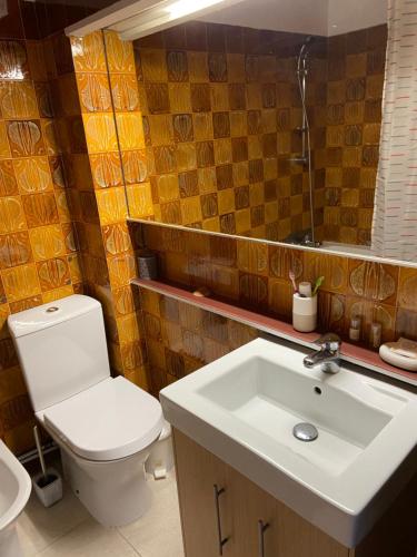 ein Badezimmer mit einem weißen WC und einem Waschbecken in der Unterkunft Ana Sun in Albufeira