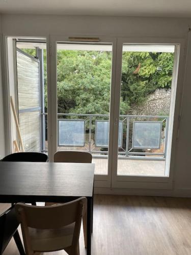 a dining room with a table and a large window at Le Bon Quai in Grenoble