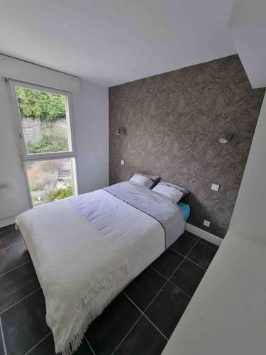 a bedroom with a large bed with a window at Le Bon Quai in Grenoble