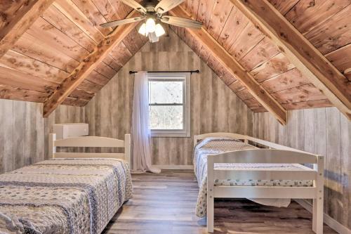 een slaapkamer met 2 bedden en een plafondventilator bij El Dorado Springs Cabin Near Trails and Parks! in El Dorado Springs