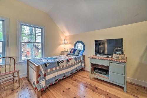 a bedroom with a bed and a tv and a desk at Waterfront Cheboygan Home with Fire Pit in Cheboygan