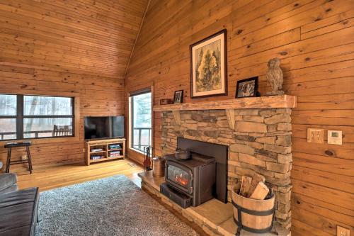 a living room with a stone fireplace and a tv at Charming Cabin with Hot Tub, Fire Pit and Views! in Jasper