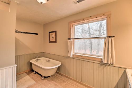 a bathroom with a bath tub and a window at Charming Cabin with Hot Tub, Fire Pit and Views! in Jasper