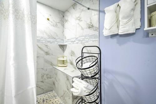 a bathroom with white marble walls and a towel rack at Joppatowne Home with Private Deck and Fireplace! 