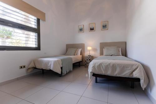 a bedroom with two beds and a window at Villa Serenity in Tías