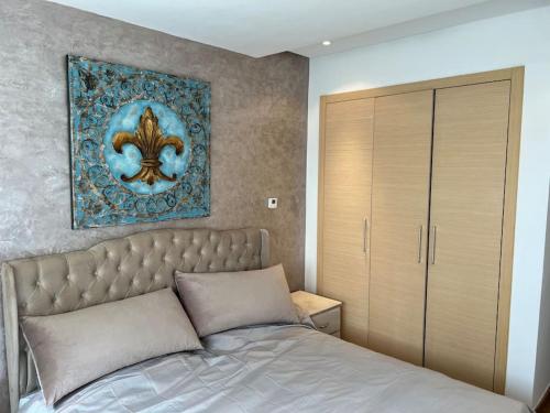 1 dormitorio con 1 cama y una pintura en la pared en Superbe appartement avec piscine en Rabat