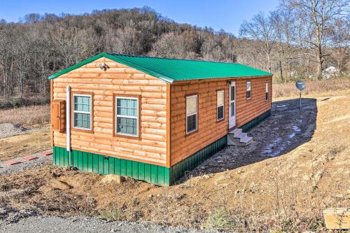 a log cabin with a green roof in a field at Laurelville Cabin Less Than 11 Mi to Old Mans Cave! in Laurelville