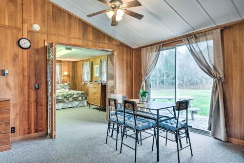 ein Esszimmer mit einem Tisch und Stühlen sowie ein Schlafzimmer in der Unterkunft Cozy New Hampshire Cottage with Deck! in Franconia