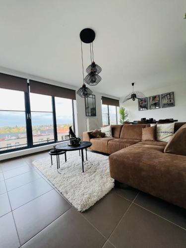 a large living room with a couch and a table at Penthouse with awesome terrace and free parking in Kortrijk