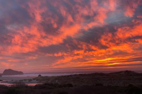 a sunset over the ocean with a cloudy sky at Ocean Song in Bandon