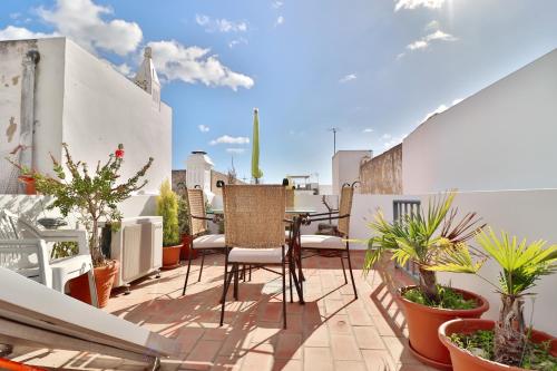 d'un balcon avec des chaises et des plantes sur le toit. dans l'établissement Zenit charm Olhao relax cubist House, à Olhão