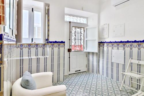 un soggiorno con sedia bianca e finestra di Zenit charm Olhao relax cubist House a Olhão