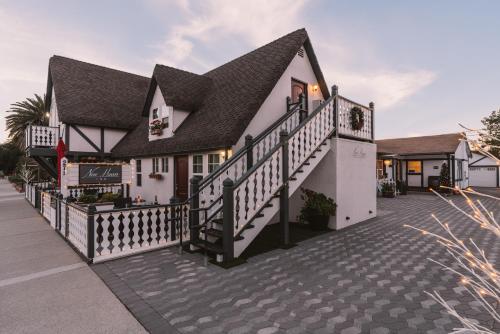 a white house with a black roof and stairs at New Haven Inn in Solvang