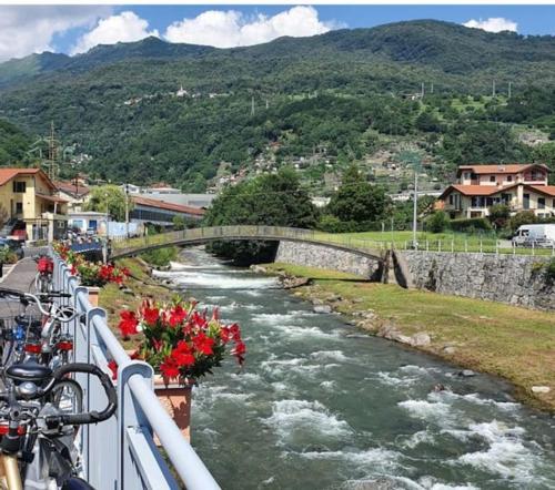 a bridge over a river with flowers in a town at Art Music House Lake Como Dongo in Dongo