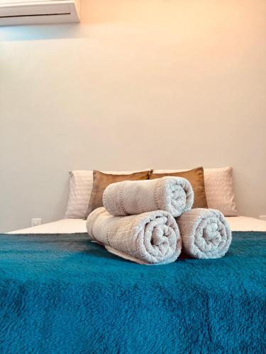 a pile of towels sitting on top of a bed at Portuá Chalés in São Miguel dos Milagres