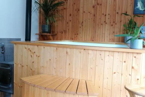 a wooden tub with a bench in front of it at Gîte de l'Oustal in Oust