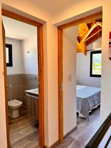 a room with a bathroom and a bed and a sink at Complejo Camino al Lago in Lago Puelo