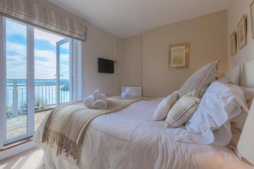 a bedroom with a large bed with a large window at Tremorna Vista in Carbis Bay