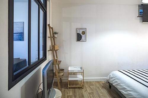 - une chambre avec une télévision à écran plat et un lit dans l'établissement Le Cosy Pasteur 5 min Hypercentre Parking public gratuit à proximité, à Troyes