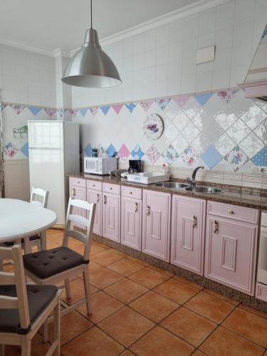 una cucina con armadietti rosa e tavolo di Mar a Isla del Moral