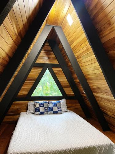 uma cama no meio de um quarto com uma janela em Pozas y Cascadas La Presa em Río Cuarto