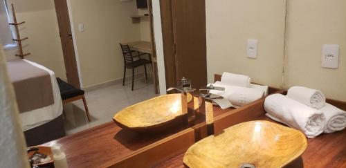 a bathroom with a wooden sink and a bed at Pousada Villa Zena - Pé na areia in Arraial d'Ajuda