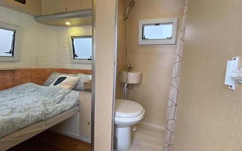 a small bathroom with a toilet and a bed at Stellar GoldenHill Cameron in Tanah Rata