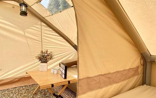 a tent with a wooden table in it at Stellar GoldenHill Cameron in Tanah Rata
