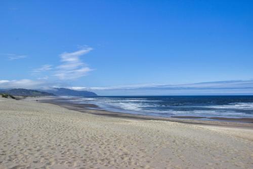 a sandy beach with the ocean in the background at The Kiwanda Surf House in Pacific City