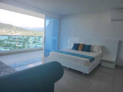 1 dormitorio con cama y ventana grande en Apartaestudio Reserva del Mar Playa Salguero Santa Marta, en Santa Marta
