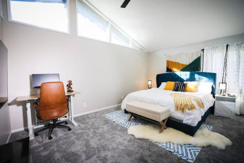 Schlafzimmer mit einem Bett, einem Schreibtisch und einem Stuhl in der Unterkunft Luxury 5 bedroom home with Pool. in Overland Park