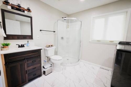 ein Bad mit einer Dusche, einem WC und einem Waschbecken in der Unterkunft Luxury 5 bedroom home with Pool. in Overland Park