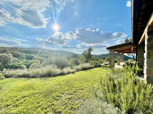 a view of a grassy field next to a house at Villa Podere Del Grasso in Castel del Piano
