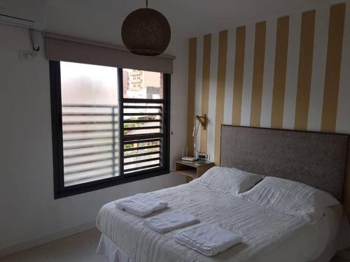 1 dormitorio con 1 cama con 2 toallas en Grand Comfy Piedras - en Barrio Sur en San Miguel de Tucumán