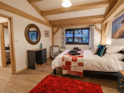 a bedroom with a large bed and a red rug at Lady Bagots Cabin in Ruthin