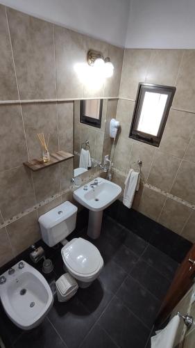 a bathroom with a white toilet and a sink at Altos del Campo in San José