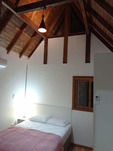 1 dormitorio con cama y techo de madera en Casa Medieval, en Gramado