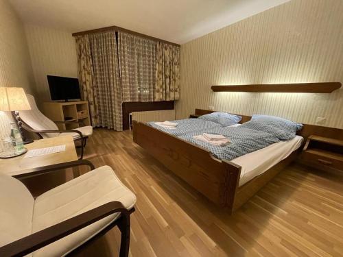 Beny Hotel Restaurant في باد بيلنغن: غرفة نوم بسرير واريكة وتلفزيون