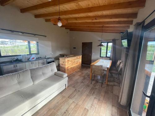 sala de estar con sofá blanco y cocina en Patagonia en Trevelín