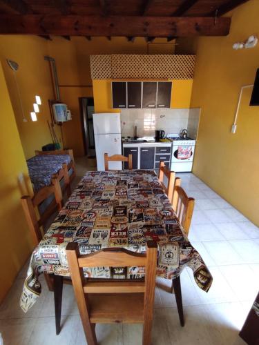 a dining room table with chairs and a kitchen at Residencial Julia in Mar de Ajó
