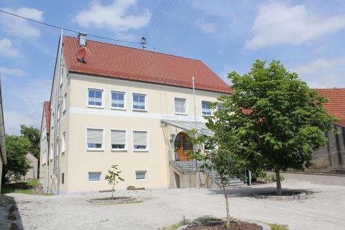 a large white building with a tree in front of it at Landgasthof Weberhans in Harburg