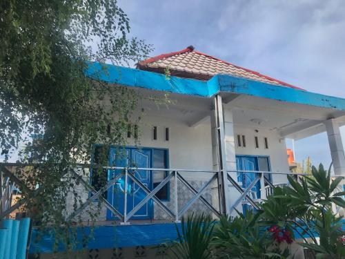 een wit en blauw huis met blauwe deuren bij The House Hostel in Gili Trawangan