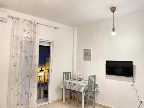 マラガにあるLuna Ensuites Centroのダイニングルーム(テーブル、壁掛けテレビ付)