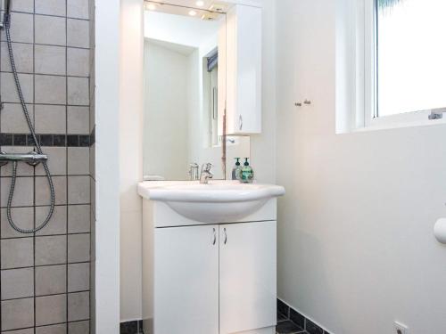 een witte badkamer met een wastafel en een spiegel bij Holiday Home Haregade II in Hovborg